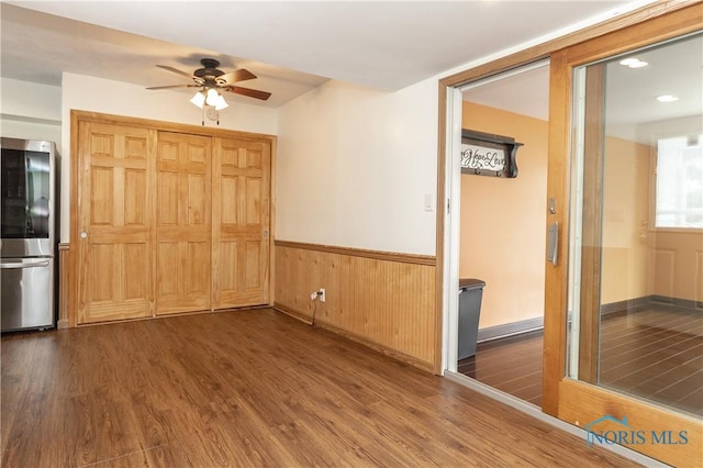 512 State St, Elmore, OH 43416 - empty room with ceiling fan, wood finished floors, a wainscoted wall, and wood walls