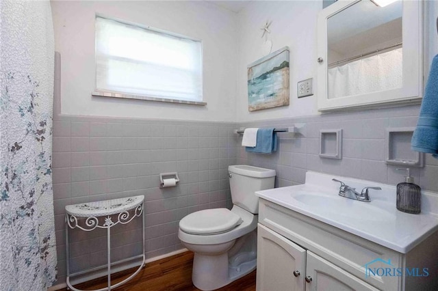 1201 S Blanchard St, Findlay, OH 45840 - full bathroom with tile walls, vanity, wainscoting, wood finished floors, and a shower with shower curtain