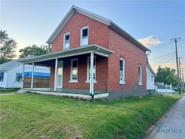 310 Hopkins St, Defiance, OH 43512 - view of front of home featuring a porch, a front lawn, and brick siding