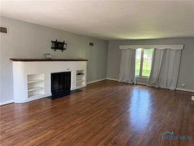 610 E High St, Defiance, OH 43512 - unfurnished living room featuring wood finished floors, a fireplace, and built in features