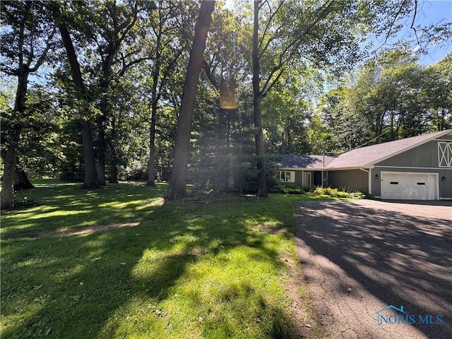 639 S Main St, Swanton, OH 43558 - view of front of home with a garage, a front yard, and driveway