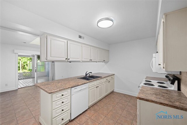 639 S Main St, Swanton, OH 43558 - kitchen featuring white appliances, light tile patterned floors, white cabinetry, and a peninsula