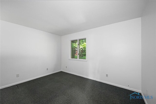 639 S Main St, Swanton, OH 43558 - empty room with dark carpet and baseboards