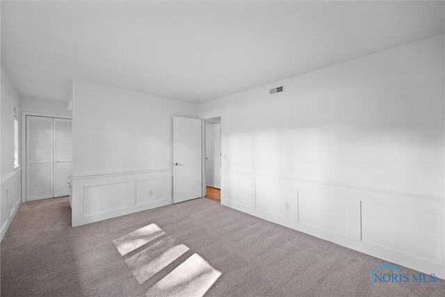 639 S Main St, Swanton, OH 43558 - unfurnished bedroom with a decorative wall, carpet, and wainscoting