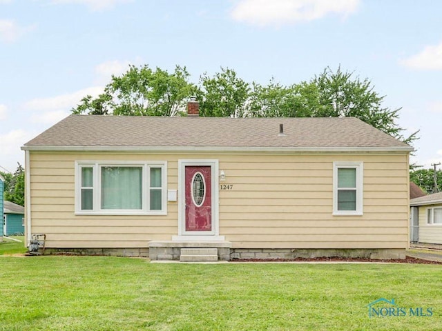 1247 Hugo St, Maumee, OH 43537 - view of front facade featuring a front lawn and a chimney