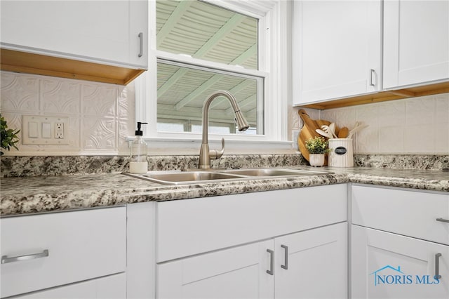 1247 Hugo St, Maumee, OH 43537 - kitchen featuring white cabinetry, decorative backsplash, and light stone countertops