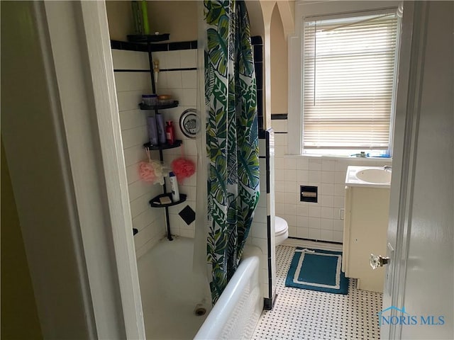 2615 Greenway St, Toledo, OH 43607 - full bathroom featuring tile walls, plenty of natural light, shower / tub combo, vanity, and wainscoting