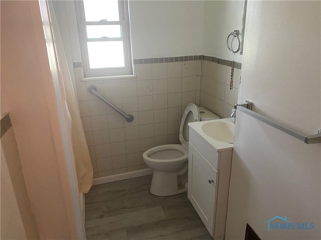 2534 Montebello Rd, Toledo, OH 43607 - full bath featuring wood finished floors, tile walls, and vanity