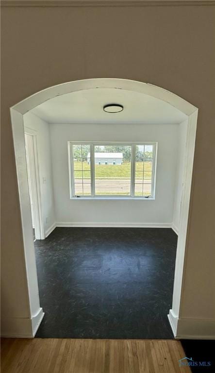 335 E N St, Mcclure, OH 43534 - empty room with arched walkways and dark wood-style flooring