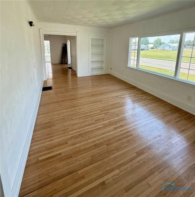 335 E N St, Mcclure, OH 43534 - unfurnished room featuring crown molding, built in shelves, and light wood-type flooring