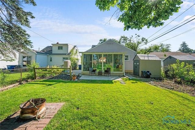 2958 Penrose Ave, Toledo, OH 43614 - rear view of house featuring an outdoor fire pit, a sunroom, a patio area, and a storage unit