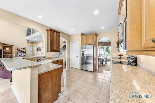 9701 Preakness Ln, Whitehouse, OH 43571 - kitchen with appliances with stainless steel finishes, arched walkways, a peninsula, recessed lighting, and light tile patterned floors