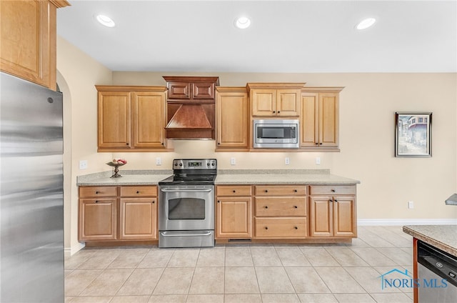 9701 Preakness Ln, Whitehouse, OH 43571 - kitchen with stainless steel appliances, premium range hood, recessed lighting, light tile patterned floors, and arched walkways