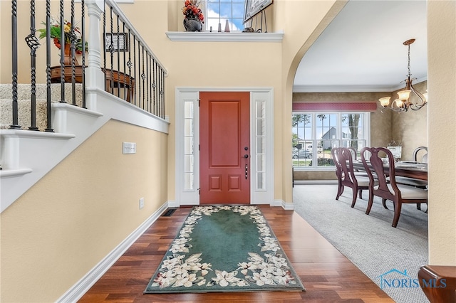9701 Preakness Ln, Whitehouse, OH 43571 - entryway with a chandelier, arched walkways, dark wood-style flooring, and stairs
