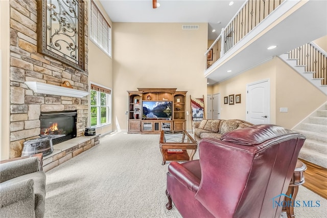 9701 Preakness Ln, Whitehouse, OH 43571 - living area with stairs, a towering ceiling, a stone fireplace, recessed lighting, and carpet flooring