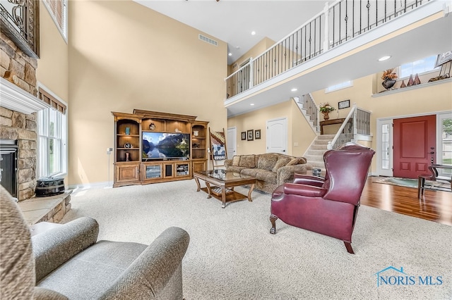 9701 Preakness Ln, Whitehouse, OH 43571 - carpeted living room with a high ceiling, stairs, and a stone fireplace