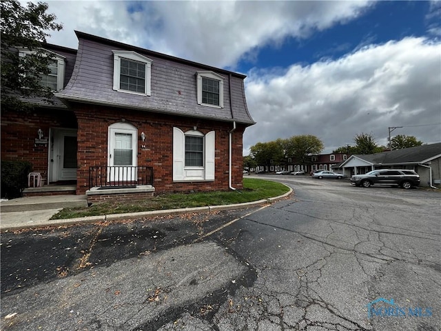 3217 Glanzman Rd Unit 14, Toledo, OH 43614 - view of front of property featuring mansard roof, brick siding, and uncovered parking
