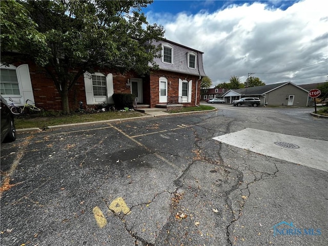 3217 Glanzman Rd Unit 14, Toledo, OH 43614 - view of front of home featuring mansard roof, brick siding, and uncovered parking
