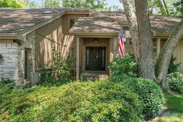 7118 Jamesford Dr, Toledo, OH 43617 - doorway to property featuring a shingled roof and brick siding