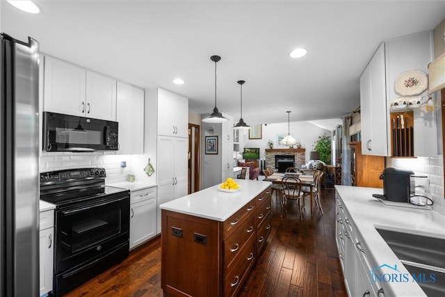 7118 Jamesford Dr, Toledo, OH 43617 - kitchen with black appliances, open floor plan, light countertops, white cabinets, and a stone fireplace