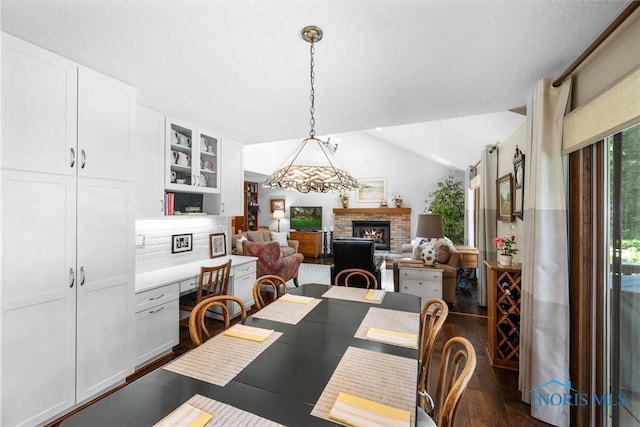 7118 Jamesford Dr, Toledo, OH 43617 - dining room with lofted ceiling, a brick fireplace, and dark wood-style flooring