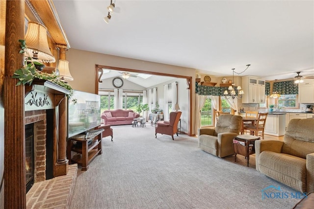 706 Grandview Ct, Elmore, OH 43416 - living area with a ceiling fan, vaulted ceiling, a fireplace, and light colored carpet
