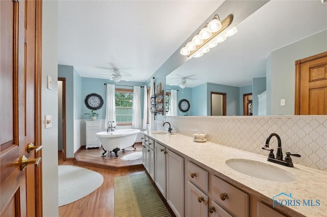 706 Grandview Ct, Elmore, OH 43416 - bathroom featuring tasteful backsplash, a ceiling fan, double vanity, wood finished floors, and a freestanding tub
