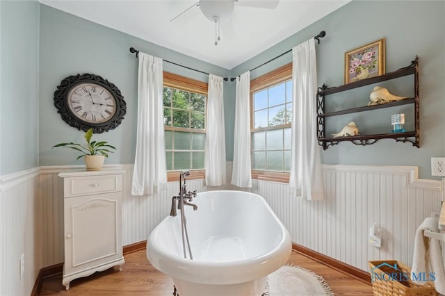 706 Grandview Ct, Elmore, OH 43416 - full bathroom with a wainscoted wall, a soaking tub, wood finished floors, and a ceiling fan