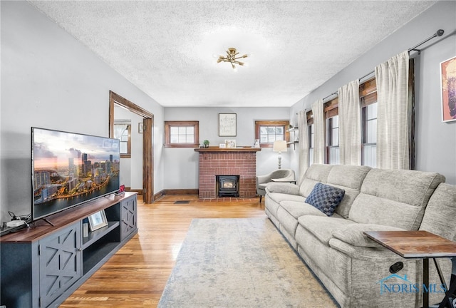 3162 Glanzman Rd, Toledo, OH 43614 - living room featuring light wood finished floors, a textured ceiling, and a fireplace