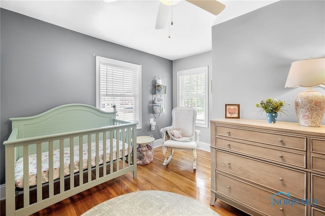 3162 Glanzman Rd, Toledo, OH 43614 - bedroom featuring wood finished floors, a nursery area, and a ceiling fan