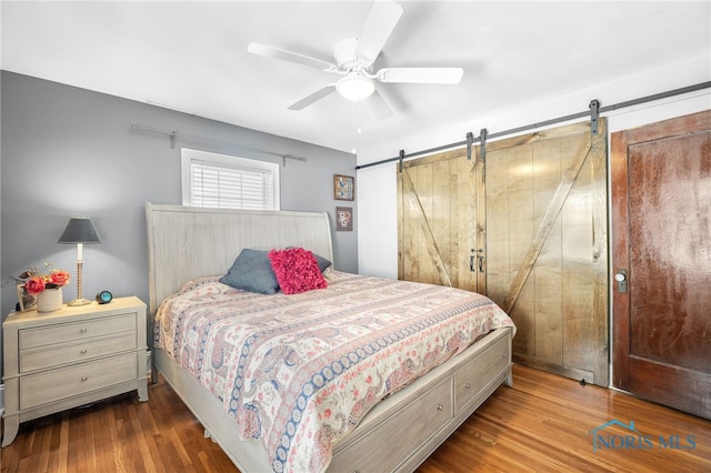 3162 Glanzman Rd, Toledo, OH 43614 - bedroom with a barn door, wood finished floors, and ceiling fan