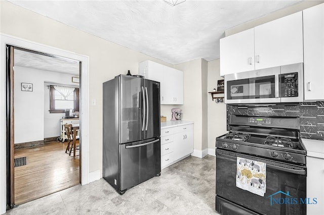 3162 Glanzman Rd, Toledo, OH 43614 - kitchen with appliances with stainless steel finishes, white cabinetry, light countertops, and decorative backsplash
