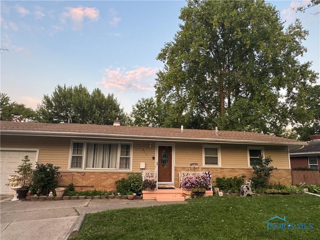 642 Mackow Dr, Toledo, OH 43607 - ranch-style house with brick siding, a chimney, and a garage