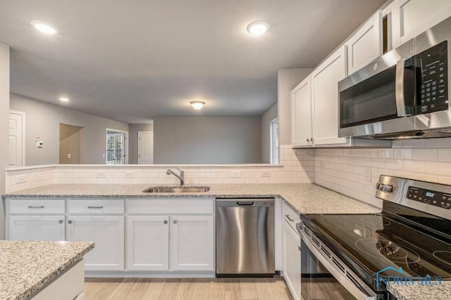 1492 Lee Ann Ave, Defiance, OH 43512 - kitchen with appliances with stainless steel finishes, white cabinets, light stone counters, decorative backsplash, and recessed lighting