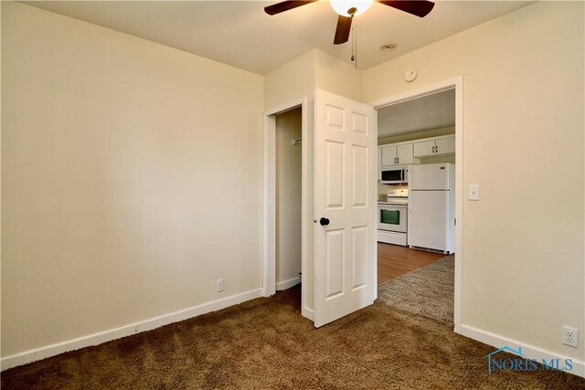 4134 Angola Rd, Toledo, OH 43615 - unfurnished bedroom featuring freestanding refrigerator, dark carpet, and ceiling fan