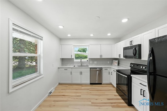 1118 Michigan Ave, Maumee, OH 43537 - kitchen with black appliances, light countertops, backsplash, white cabinets, and recessed lighting