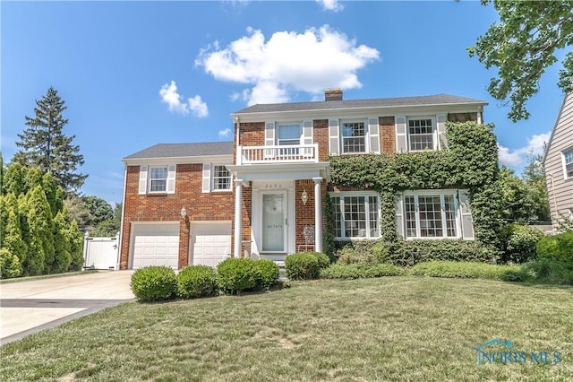 2403 Hempstead Rd, Ottawa Hills, OH 43606 - view of front of home with driveway, brick siding, a garage, a front lawn, and a chimney