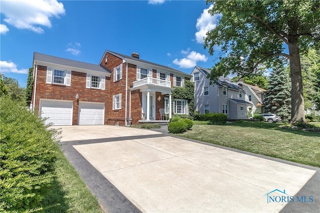 2403 Hempstead Rd, Ottawa Hills, OH 43606 - view of front of property with brick siding, driveway, an attached garage, a chimney, and a front lawn