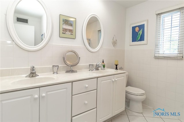 2403 Hempstead Rd, Ottawa Hills, OH 43606 - full bathroom with tile walls, double vanity, tile patterned floors, and a wainscoted wall