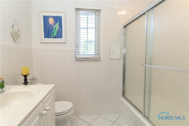 2403 Hempstead Rd, Ottawa Hills, OH 43606 - bathroom featuring tile walls, vanity, tile patterned floors, combined bath / shower with glass door, and wainscoting