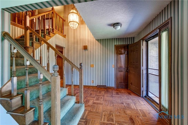 6608 Inglewood Dr, Holland, OH 43528 - foyer with wallpapered walls, stairway, and a textured ceiling