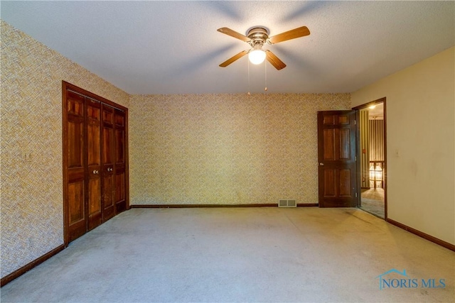 6608 Inglewood Dr, Holland, OH 43528 - unfurnished bedroom with carpet floors, a ceiling fan, a closet, and wallpapered walls