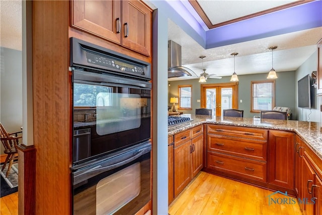 312 W Dudley St, Maumee, OH 43537 - kitchen featuring ventilation hood, light wood-style flooring, light stone countertops, and brown cabinetry
