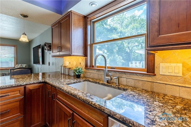 312 W Dudley St, Maumee, OH 43537 - kitchen featuring pendant lighting, decorative backsplash, dark stone counters, a peninsula, and a textured ceiling