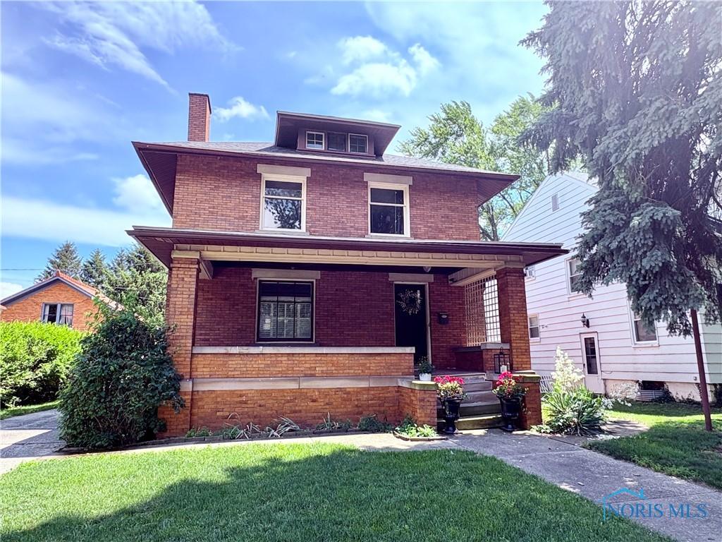 617 Holgate Ave, Defiance, OH 43512 - american foursquare style home featuring brick siding, covered porch, a chimney, and a front yard