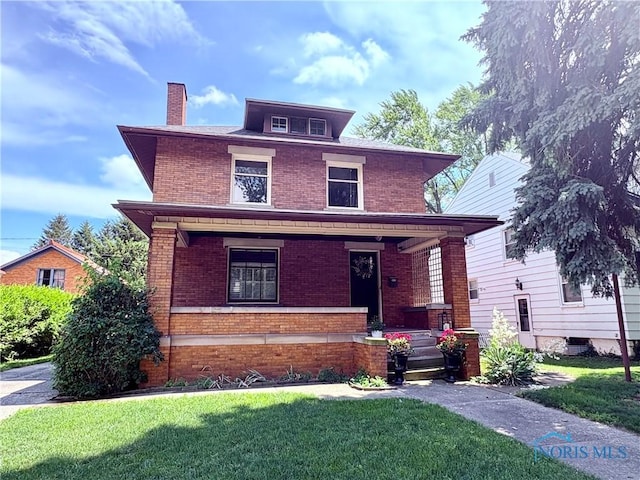 617 Holgate Ave, Defiance, OH 43512 - american foursquare style home featuring brick siding, covered porch, a chimney, and a front yard