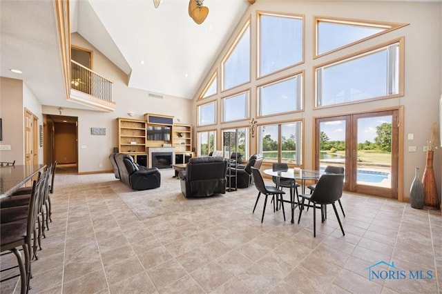 586 N State Route 587, Fostoria, OH 44830 - dining space featuring high vaulted ceiling, french doors, a glass covered fireplace, and light tile patterned floors