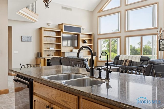 586 N State Route 587, Fostoria, OH 44830 - kitchen with dishwashing machine, high vaulted ceiling, healthy amount of natural light, open floor plan, and dark stone countertops