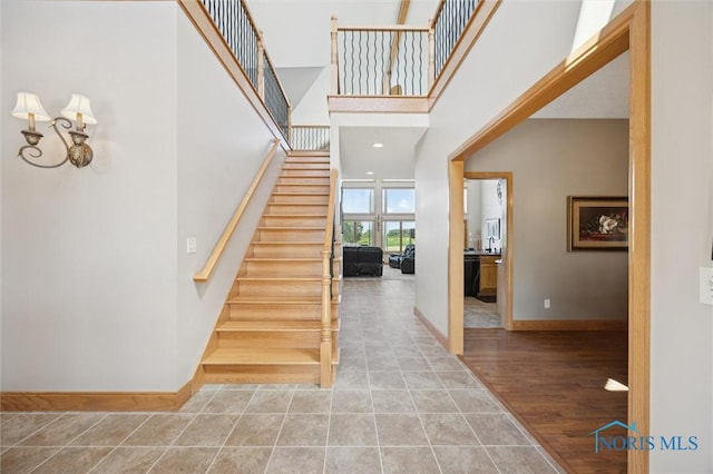 586 N State Route 587, Fostoria, OH 44830 - stairs with tile patterned flooring, a towering ceiling, and a chandelier