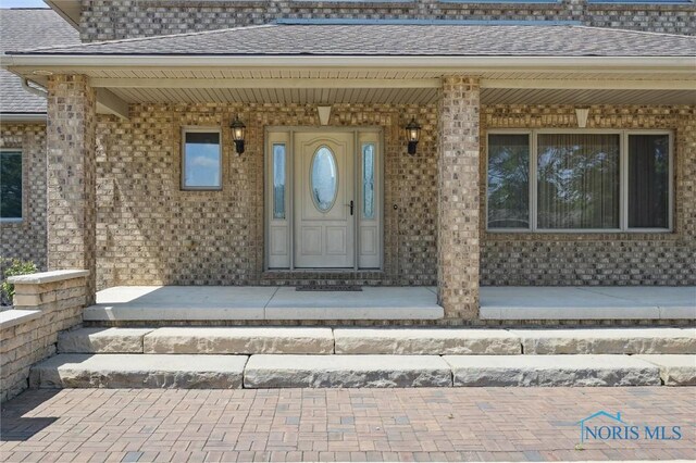 586 N State Route 587, Fostoria, OH 44830 - property entrance with brick siding, a shingled roof, and a porch